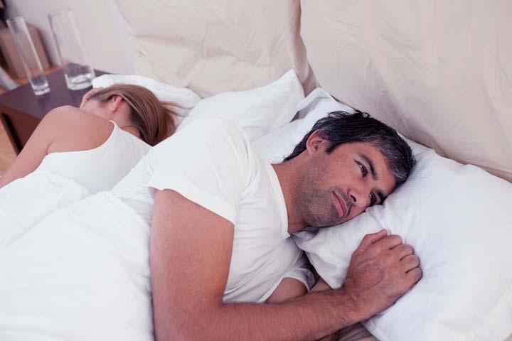 man lying in bed thinking about sexual performance anxiety erectile dysfunction