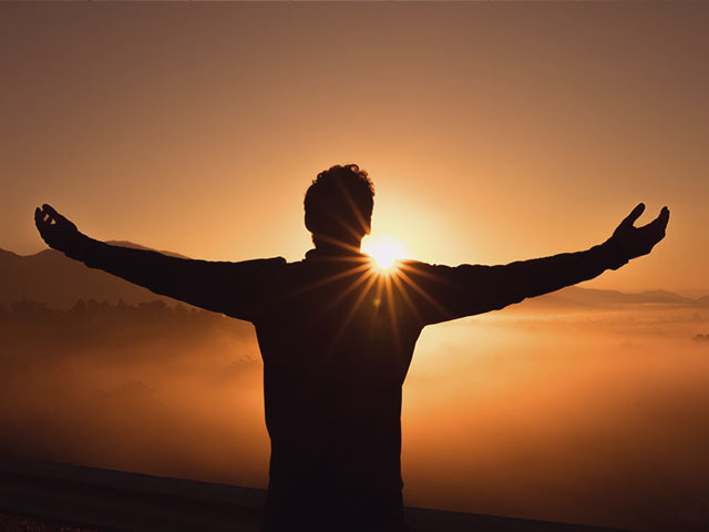 A man standing at the sun being present